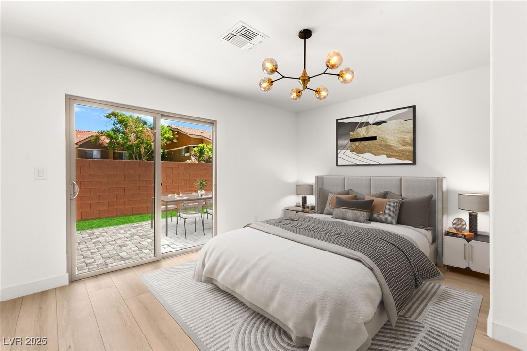 5606 Spring Trellis Street Las Vegas, NV 89113 - Photo 6 of 44 Bedroom with light wood-style floors, access to exterior, and a chandelier