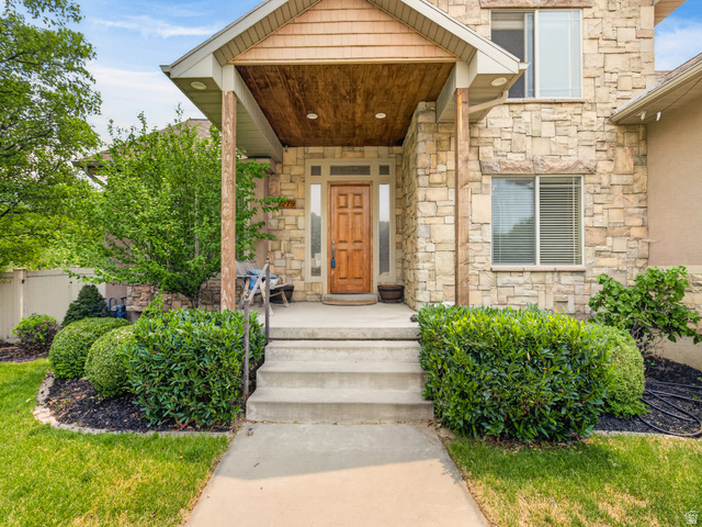 1279 West 1500th Street North Mapleton, UT 84664 - Photo 5 of 83 Stone facade entry with a wood-finish front door, covered porch, and integrated recessed lighting