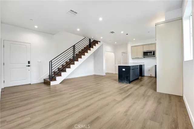 a view of kitchen and hall with wooden floor