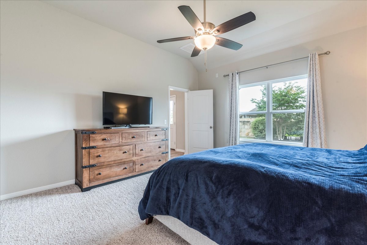125 Groesbeck Lane Leander, TX 78641 - Photo 16 of 38 a bedroom with a bed and a flat screen tv