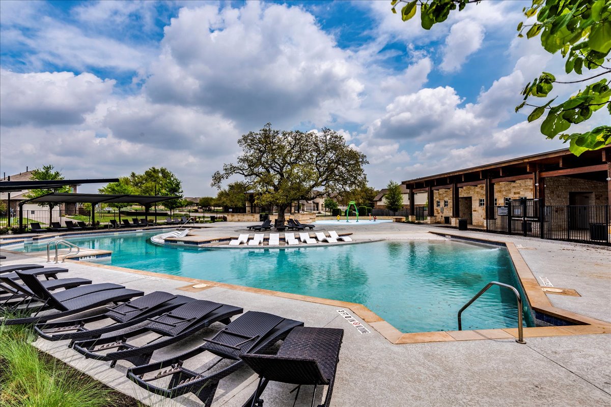 125 Groesbeck Lane Leander, TX 78641 - Photo 35 of 38 a view of swimming pool that has lawn chairs with plants and lake view