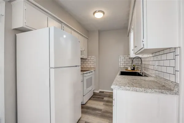 a kitchen with a refrigerator a stove and a sink