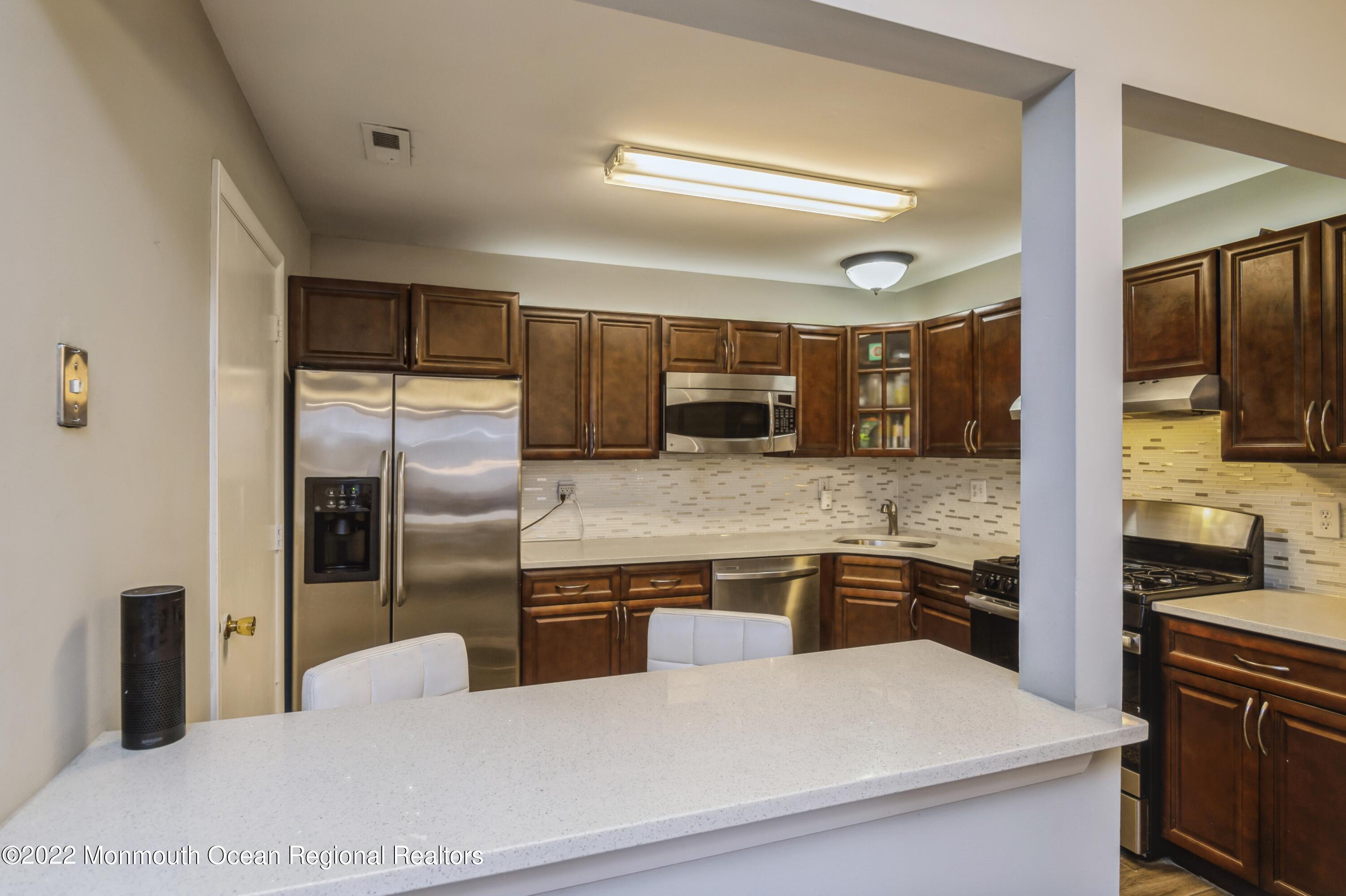 503 Harding Road, Unit 5 Freehold, NJ 07728 - Photo 5 of 21 a kitchen with stainless steel appliances granite countertop a refrigerator and a stove