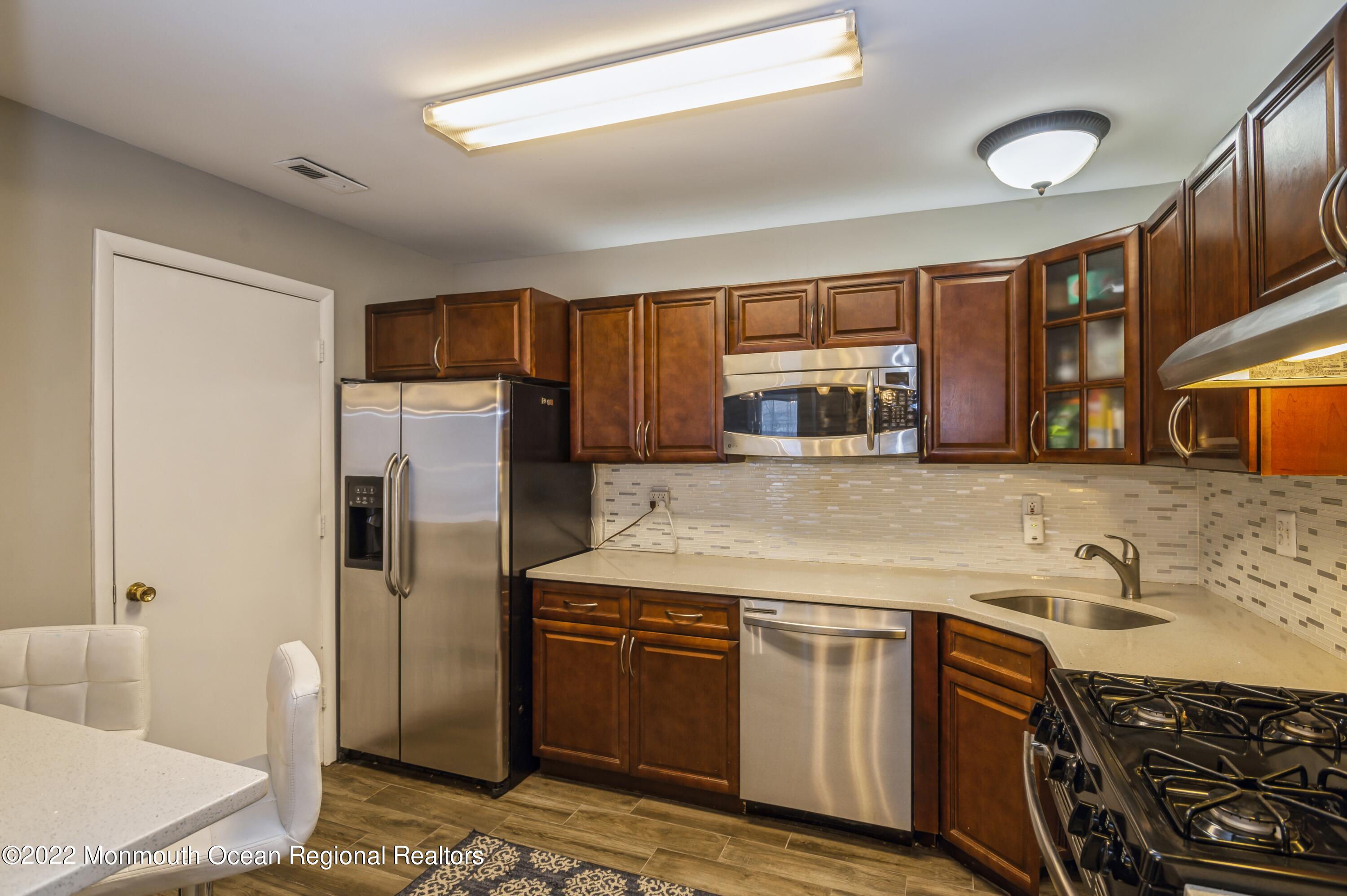 503 Harding Road, Unit 5 Freehold, NJ 07728 - Photo 6 of 21 a kitchen with stainless steel appliances granite countertop a stove a sink and a refrigerator