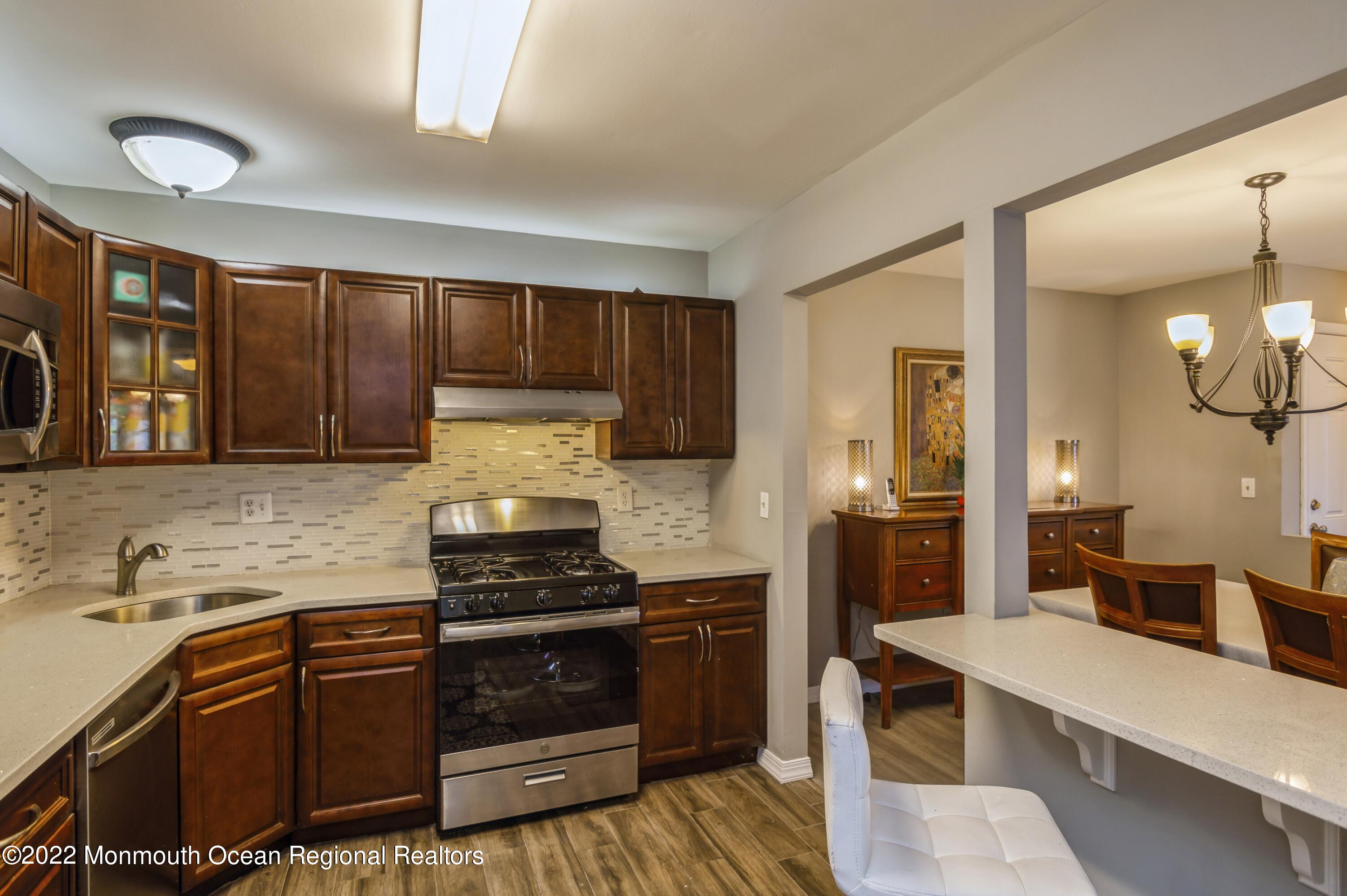 503 Harding Road, Unit 5 Freehold, NJ 07728 - Photo 7 of 21 a kitchen with granite countertop a stove and cabinets