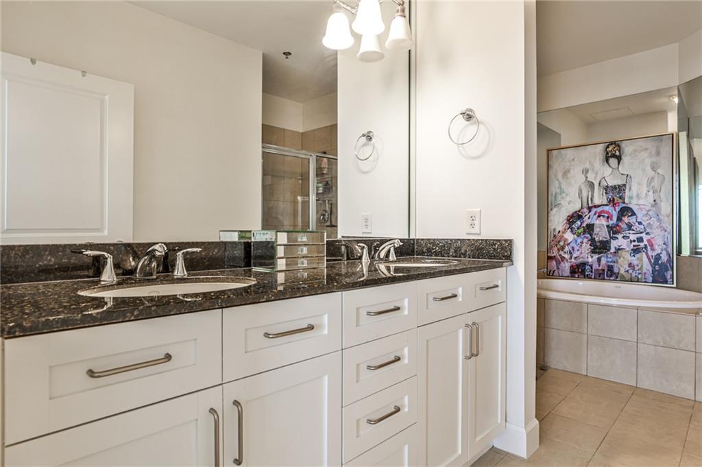 325 East Paces Ferry Road Northeast, Unit 1105 Atlanta, GA 30305 - Photo 13 of 36 a bathroom with a granite countertop sink and a mirror