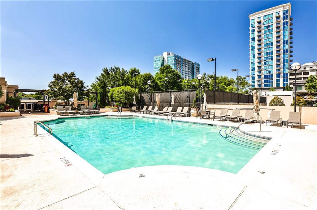 325 East Paces Ferry Road Northeast, Unit 1105 Atlanta, GA 30305 - Photo 29 of 36 a view of a swimming pool with a lawn chairs and plants