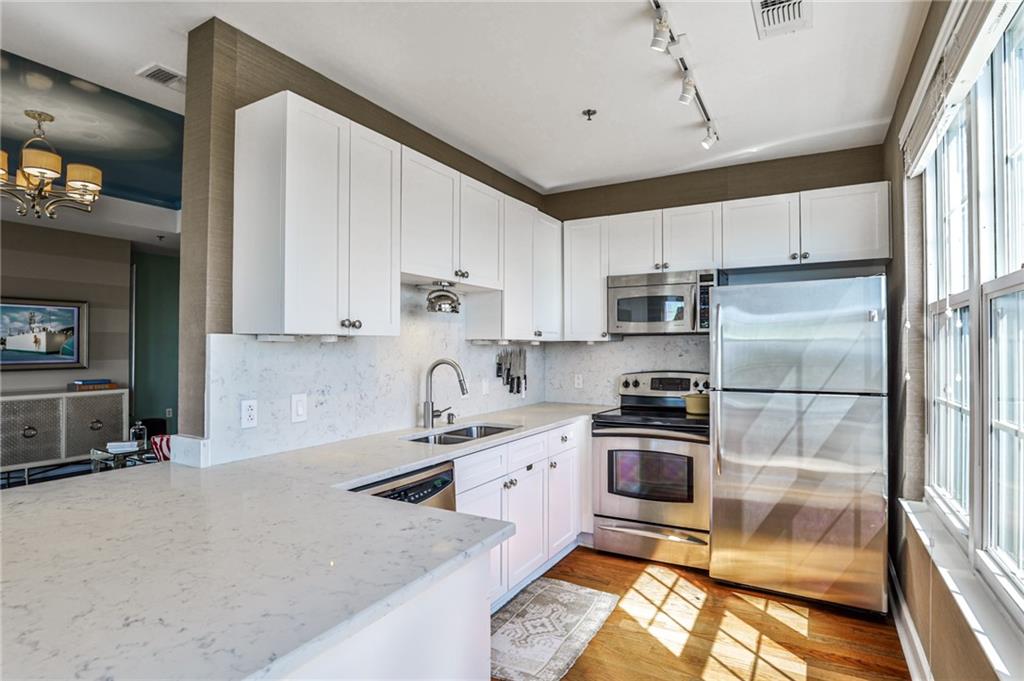 325 East Paces Ferry Road Northeast, Unit 1105 Atlanta, GA 30305 - Photo 6 of 36 a kitchen with stainless steel appliances a stove a sink and a refrigerator