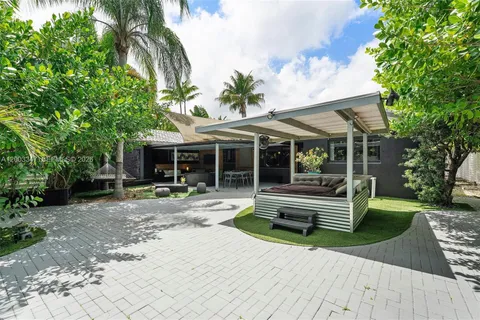 a view of a house with backyard sitting area and garden