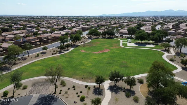 an aerial view of residential houses with outdoor space and trees