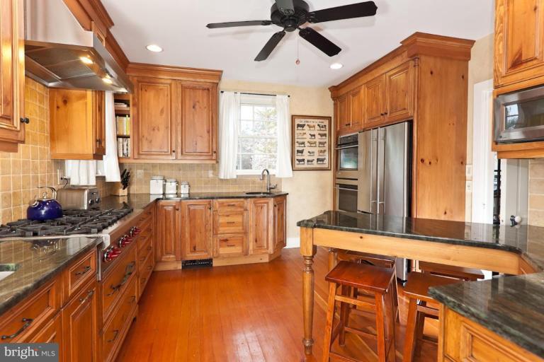 221 Tunbridge Road Baltimore, MD 21212 - Photo 6 of 14 a kitchen with stainless steel appliances granite countertop a sink a stove and a refrigerator
