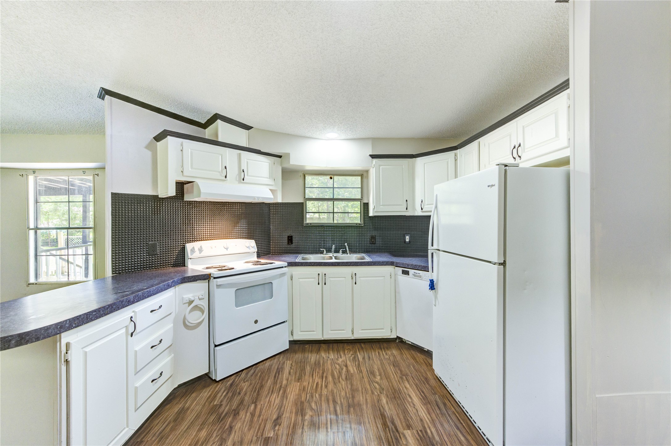 26342 Hunters Trail New Caney, TX 77357 - Photo 6 of 25 a kitchen with white cabinets and white appliances