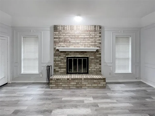 wooden floor fireplace and windows in an empty room