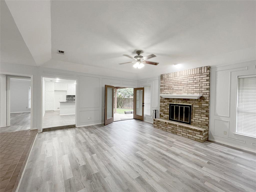 7716 Harmony Drive Fort Worth, TX 76133 - Photo 15 of 40 wooden floor fireplace and windows in an empty room