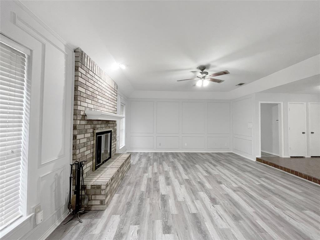 7716 Harmony Drive Fort Worth, TX 76133 - Photo 16 of 40 wooden floor in an empty room with a fireplace