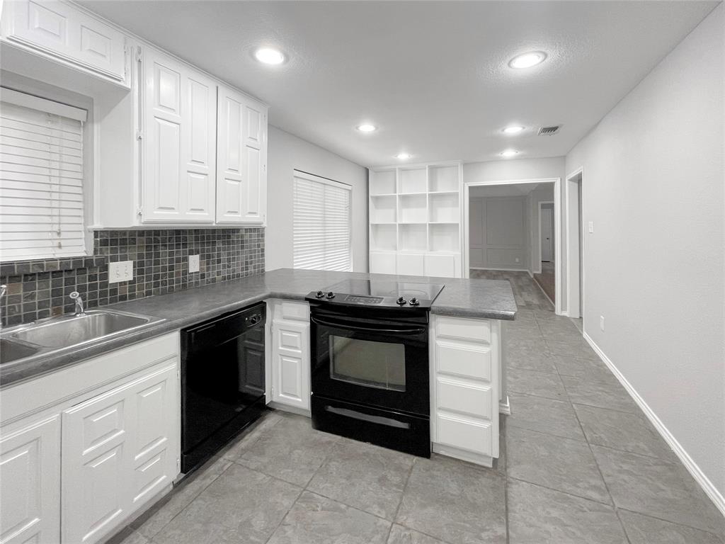 7716 Harmony Drive Fort Worth, TX 76133 - Photo 20 of 40 a kitchen with kitchen island granite countertop white cabinets and stainless steel appliances