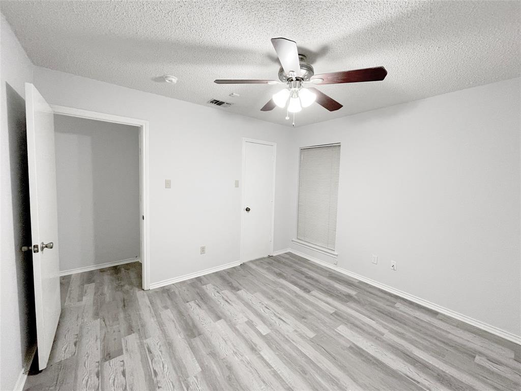 7716 Harmony Drive Fort Worth, TX 76133 - Photo 25 of 40 an empty room with wooden floor fan and windows