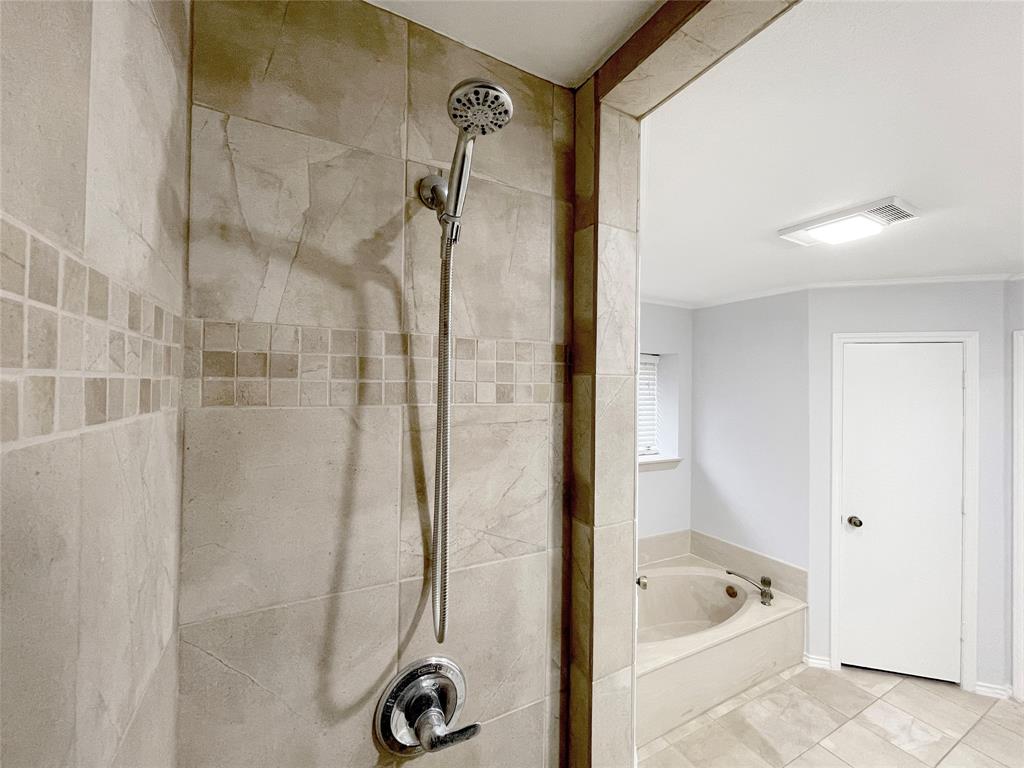 7716 Harmony Drive Fort Worth, TX 76133 - Photo 28 of 40 a bathroom with a tub a sink and shower