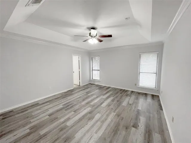 a view of empty room with wooden floor