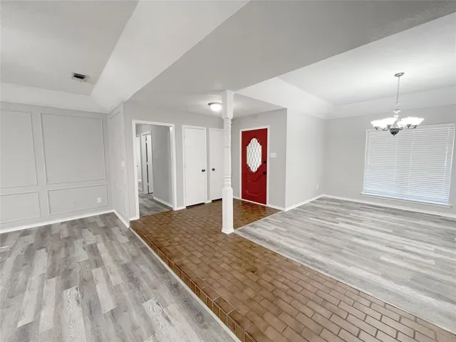 a view of a room with wooden floor and entryway