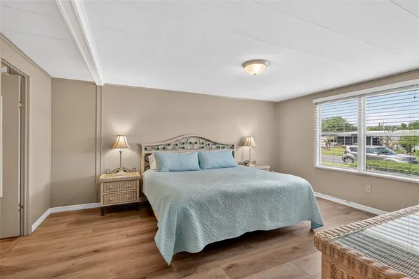 a bedroom with a bed and wooden floor