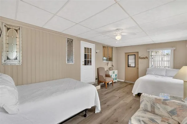 a spacious bedroom with a bed and wooden floor