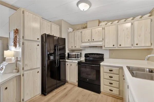 a kitchen with a refrigerator sink and cabinets