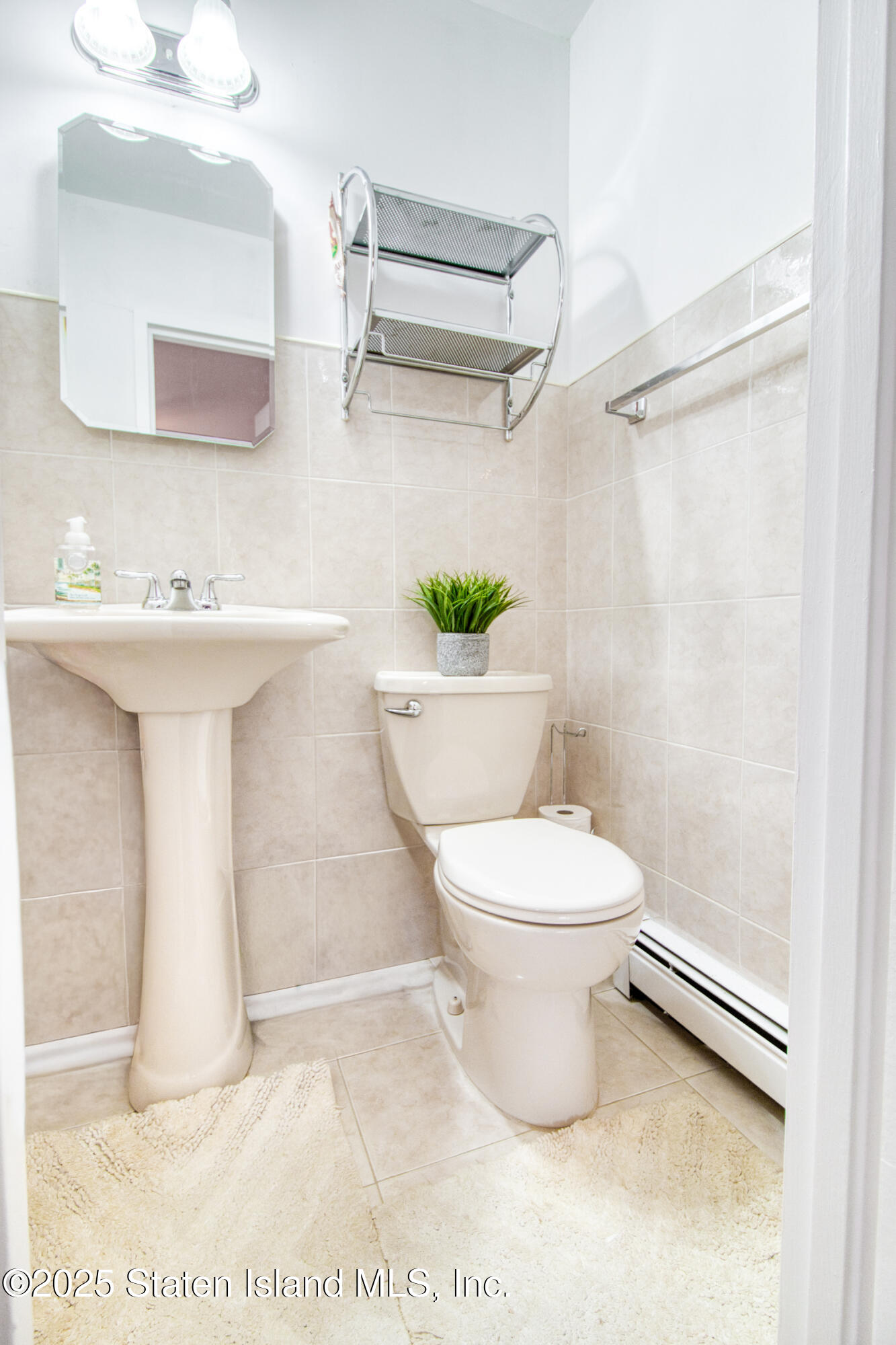 52 Racal Court, Unit A2 Staten Island, NY 10314 - Photo 22 of 28 a bathroom with a toilet a sink and a mirror