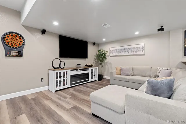 a living room with furniture a table and wooden floor