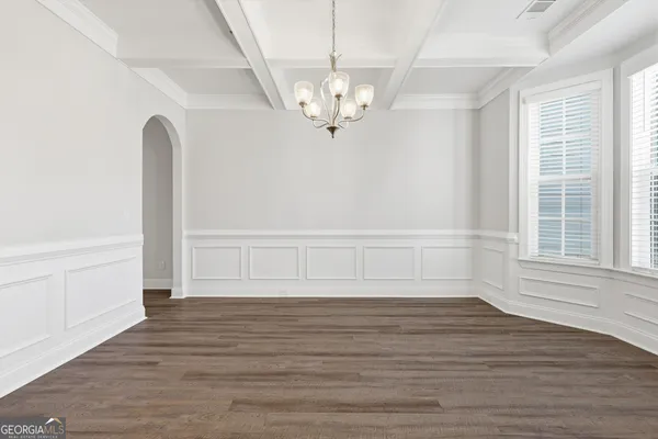 a view of a livingroom with wooden floor and a large window
