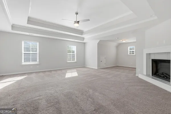 an empty room with windows and fireplace