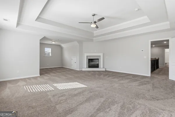 an empty room with a ceiling fan and a window
