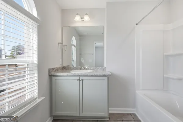 a bathroom with a granite countertop sink a toilet and bathtub