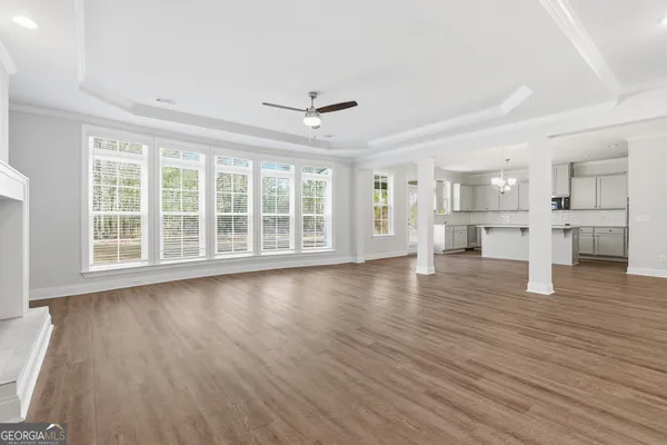 a view of empty room with wooden floor and windows