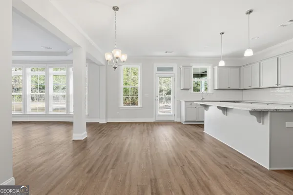 a view of a kitchen with wooden floor and windows