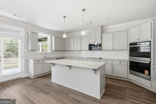 a kitchen with a sink window and stainless steel appliances