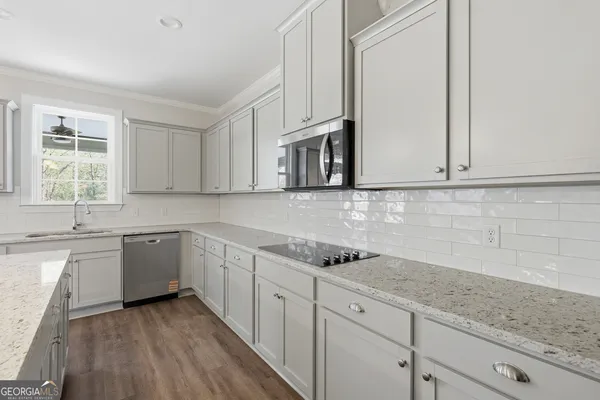 a kitchen with granite countertop cabinets stainless steel appliances a sink and window