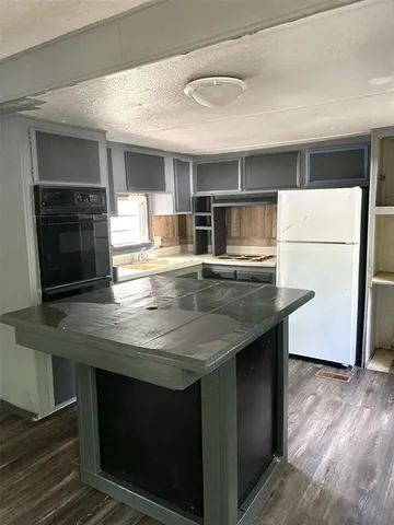 a kitchen with kitchen island a sink counter top space and stainless steel appliances