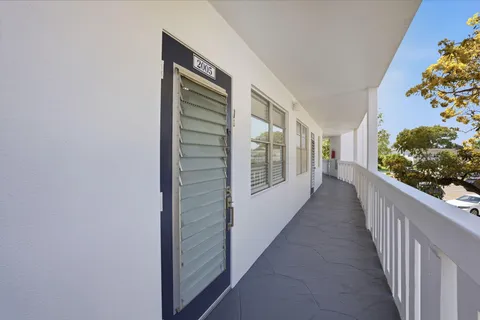 a view of a hallway with wooden floor and flower pot