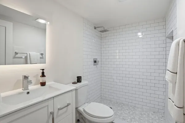 a bathroom with a sink a toilet and shower