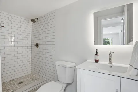 a bathroom with a sink a toilet and shower