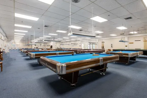 a room with pool table and windows