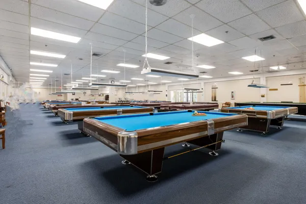 a room with pool table and windows