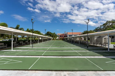 a view of a tennis ground with large trees
