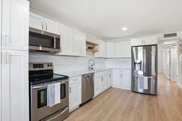 a kitchen with granite countertop a sink stainless steel appliances and cabinets