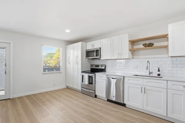a kitchen with a sink stove and cabinets