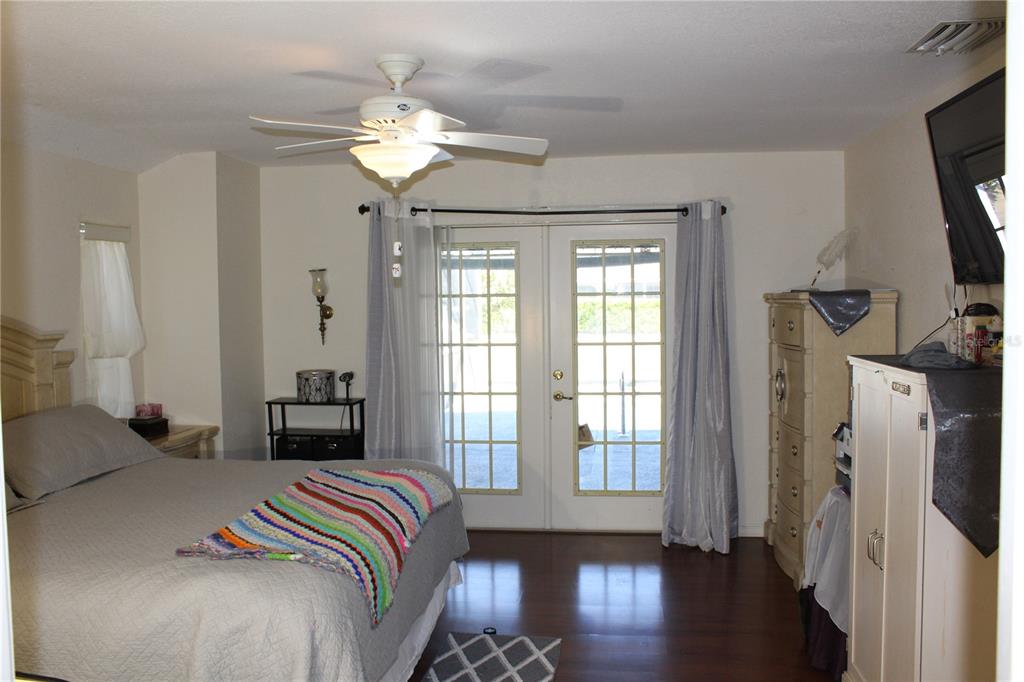 74 Belem Street Punta Gorda, FL 33983 - Photo 24 of 34 a bedroom with a bed and a chandelier
