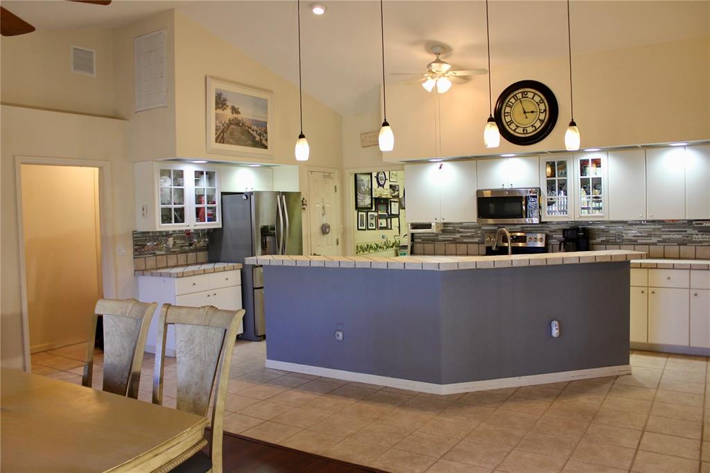 74 Belem Street Punta Gorda, FL 33983 - Photo 7 of 34 a large kitchen with stainless steel appliances granite countertop a stove a refrigerator a oven and a table with chairs