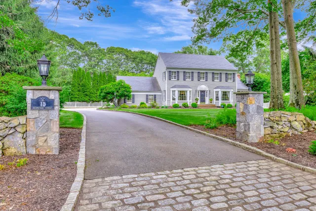 a front view of a house with a yard and potted plants
