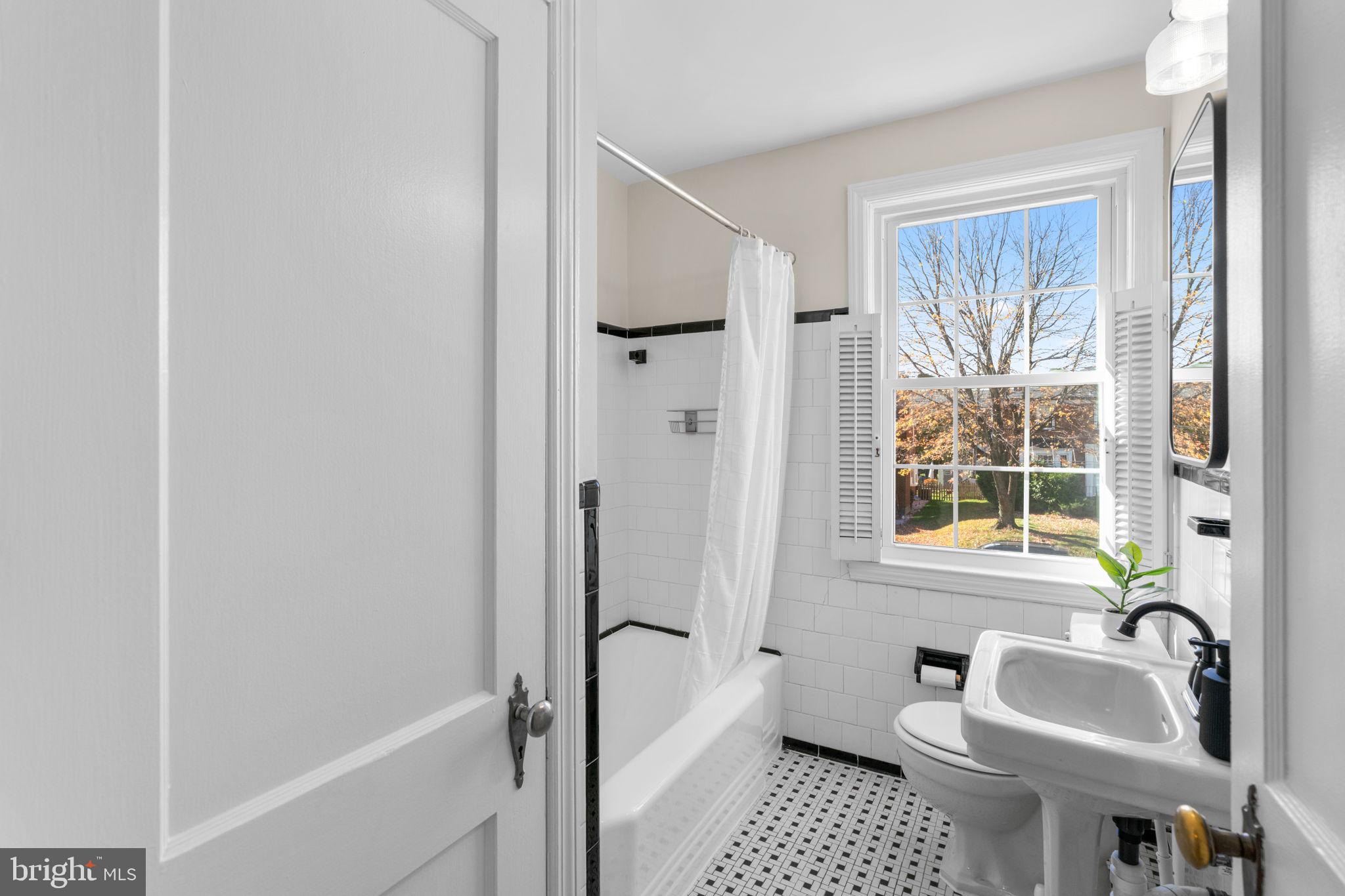 321 Stratford Road Baltimore, MD 21228 - Photo 16 of 34 a bathroom with a sink a toilet a window and shower